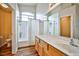Bright bathroom with a wooden vanity, large mirror, and shower-tub, ideal for relaxation at 4833 Straight Flush Dr # 103, Las Vegas, NV 89122