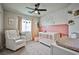 Bright Bedroom with a white crib, accent wall, neutral decor and comfy seating, perfect for a growing Gathering at 4833 Straight Flush Dr # 103, Las Vegas, NV 89122
