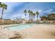 Community swimming pool surrounded by lounge chairs, mature trees, and palm trees at 4833 Straight Flush Dr # 103, Las Vegas, NV 89122