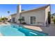 Backyard with sparkling pool, desert landscaping, stucco wall, chimney and patio with chairs for relaxing and soaking up the sun at 5104 Burr Oak Dr, Las Vegas, NV 89130
