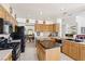 Open kitchen with a central island, wooden cabinets, and black appliances at 5104 Burr Oak Dr, Las Vegas, NV 89130