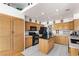 Well-lit kitchen features wooden cabinets, an island, and modern black appliances at 5104 Burr Oak Dr, Las Vegas, NV 89130
