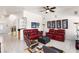 Bright living room with red leather sofas, tiled flooring, and a ceiling fan at 5104 Burr Oak Dr, Las Vegas, NV 89130