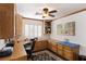 Home office with custom cabinets, built-in shelving, window with shutters, and a black desk chair at 5104 Burr Oak Dr, Las Vegas, NV 89130