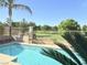 Inviting pool with palm trees and view of green golf course beyond wrought iron fence at 5104 Burr Oak Dr, Las Vegas, NV 89130