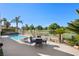 Backyard patio area has a pool, wrought iron fence, a dining set and manicured landscaping, with views of a golf course at 5104 Burr Oak Dr, Las Vegas, NV 89130