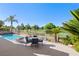 Backyard patio area has a pool, wrought iron fence, a dining set and manicured landscaping, with views of a golf course at 5104 Burr Oak Dr, Las Vegas, NV 89130
