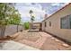 Spacious backyard featuring a covered patio, palm trees, and a brick-lined walkway at 610 Playa Del Sol Way, Henderson, NV 89015