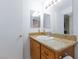 Bathroom featuring a wood cabinet and granite counters with a mirrored wall at 610 Playa Del Sol Way, Henderson, NV 89015