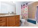 Bathroom showcasing a single sink, wood cabinet, and a tub with a colorful shower curtain at 610 Playa Del Sol Way, Henderson, NV 89015