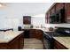 Well-equipped kitchen boasting modern appliances, granite counters, and dark wood cabinetry at 610 Playa Del Sol Way, Henderson, NV 89015