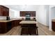 Modern kitchen with stainless steel appliances, granite countertops, island seating, and hardwood floors at 610 Playa Del Sol Way, Henderson, NV 89015
