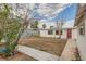 View of large backyard, mature tree and cinder block wall from yard corner at 613 Stanford St, Las Vegas, NV 89107