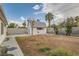 Large backyard with cinder block wall, mature trees, and outbuilding with window at 613 Stanford St, Las Vegas, NV 89107