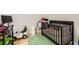 A bedroom with a wooden crib, green rug, and a small window at 613 Stanford St, Las Vegas, NV 89107