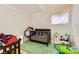 A bedroom with a wooden crib, green rug, and a small window at 613 Stanford St, Las Vegas, NV 89107