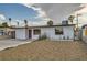 Charming single-story home featuring a minimalist front yard, unique front door, and palm trees on a sunny day at 613 Stanford St, Las Vegas, NV 89107