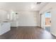 Open living space with wood floors, backyard access, and view to kitchen with white cabinets at 6140 Passionate Ct, North Las Vegas, NV 89031