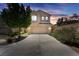 Charming two-story home with a two-car garage and front yard, illuminated by sunset at 6247 Sugartree Ave, Las Vegas, NV 89141