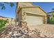 View of a two-story home with a two-car garage, beautiful landscaping, and a brick driveway at 625 Loyalty Ct, Henderson, NV 89011