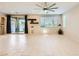 Bright living room featuring tile flooring, a ceiling fan, and a sliding glass door to the backyard at 625 Loyalty Ct, Henderson, NV 89011