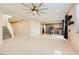 Bright living room with tile flooring, a modern ceiling fan, and an open layout flowing into the kitchen at 625 Loyalty Ct, Henderson, NV 89011