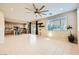 Open-concept living room with tile flooring, a kitchen, a ceiling fan, and access to the backyard at 625 Loyalty Ct, Henderson, NV 89011
