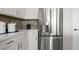 Close-up of a stainless steel refrigerator in a modern kitchen with white cabinets at 64 Via Montoro, Henderson, NV 89011