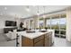 Open-concept kitchen with island, stainless steel appliances, and adjacent living area with mountain views at 64 Via Montoro, Henderson, NV 89011