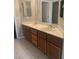 Bathroom featuring double sinks with wooden cabinetry, vanity space, and a mirror at 6412 Starling Mesa St, North Las Vegas, NV 89086