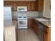 Functional kitchen with oak cabinetry, white appliances, and plenty of counter space at 6412 Starling Mesa St, North Las Vegas, NV 89086