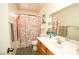 Bright bathroom with a single sink vanity, decorative flower accent, and shower with curtains at 6520 Blooming Sun Ct, Las Vegas, NV 89142