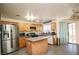 Well-lit kitchen with stainless steel refrigerator, center island, and access to the patio at 6520 Blooming Sun Ct, Las Vegas, NV 89142