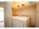 Laundry room featuring a white washer and dryer with storage shelves above at 6520 Blooming Sun Ct, Las Vegas, NV 89142