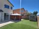 A backyard with artificial turf, a covered patio, and a storage shed at 7102 Shimmering Ave, Henderson, NV 89011