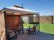 Backyard covered patio with outdoor seating, artificial turf, and mountain views at 7102 Shimmering Ave, Henderson, NV 89011
