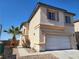 Two-story stucco home featuring a tile roof, desert landscaping, and an attached two-car garage at 7102 Shimmering Ave, Henderson, NV 89011