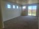 Open-plan living room featuring neutral carpet, bright walls, and sliding glass doors to the backyard at 7102 Shimmering Ave, Henderson, NV 89011