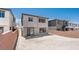 A view of the backyard with a gravel area, framed by brick walls and neighboring houses at 72 Via Montoro, Henderson, NV 89011
