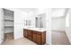 Bathroom with a double sink vanity with wood cabinets and a large mirror, adjacent to the walk-in closet at 72 Via Montoro, Henderson, NV 89011
