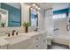 Bright bathroom featuring double sinks, white cabinets, and decorative mirrors at 7417 Radville Dr, Las Vegas, NV 89129