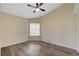 Spacious bedroom with wood-look flooring, a ceiling fan, and a large window at 7417 Radville Dr, Las Vegas, NV 89129