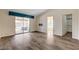 Bright bedroom with wood-look floors and slider access to the backyard, next to ensuite bathroom at 7417 Radville Dr, Las Vegas, NV 89129