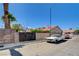 Charming single-story house featuring a terra cotta roof, desert landscaping, and privacy wall at 7417 Radville Dr, Las Vegas, NV 89129