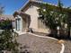 View of the private backyard featuring desert landscaping, a covered patio, and a convenient access door at 7850 Flagler St, Las Vegas, NV 89139