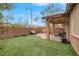 The backyard has a covered patio, seating area, artificial turf, and a stylish brick perimeter fence at 7937 Granite Walk Ave, Las Vegas, NV 89178