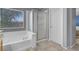 Bathroom features a soaking tub with shower, glass doors and a large window at 7937 Granite Walk Ave, Las Vegas, NV 89178