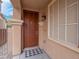 Close up of the front door with a decorative light fixture and checkered doormat at 7937 Granite Walk Ave, Las Vegas, NV 89178