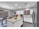 Bright kitchen features a center island, white cabinets, stainless steel refrigerator and adjacent dining area at 7937 Granite Walk Ave, Las Vegas, NV 89178