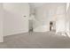 Spacious living room showcasing a staircase, chandelier, plush carpet, and tiled flooring for a modern look at 8934 Pomona Ct, Las Vegas, NV 89147